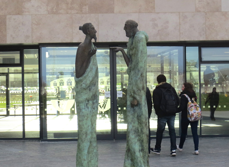 Tall statues one pointing at the other